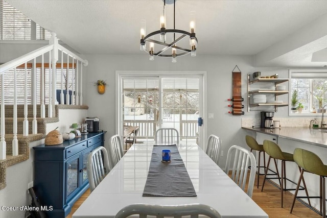 dining room featuring an inviting chandelier, a textured ceiling, and light hardwood / wood-style floors