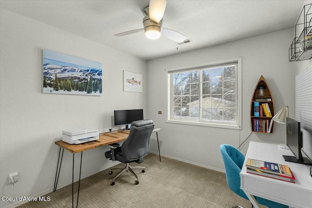 carpeted home office with a textured ceiling and ceiling fan