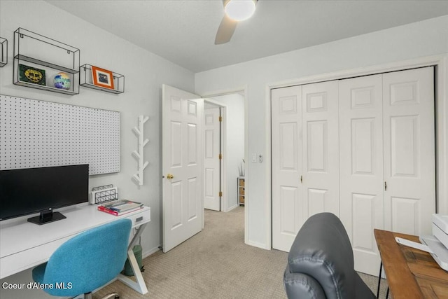 carpeted home office featuring ceiling fan