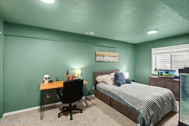 bedroom featuring light carpet and a textured ceiling