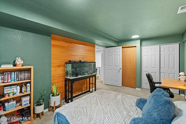 bedroom featuring multiple closets and light colored carpet