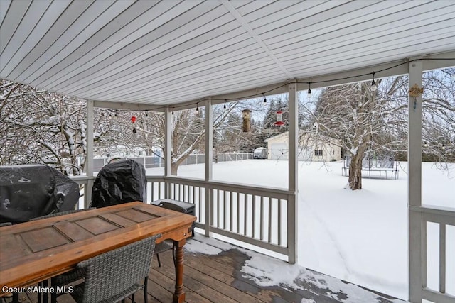 snow covered deck with a grill