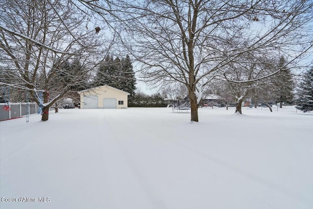 yard covered in snow with a garage and an outdoor structure