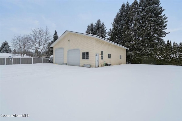 view of snowy exterior featuring a garage