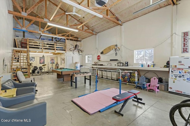 rec room with pool table, high vaulted ceiling, and concrete floors