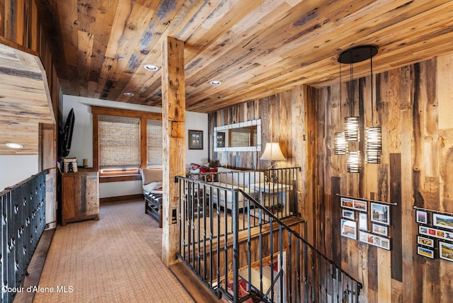 hallway with wooden walls, carpet flooring, and wood ceiling