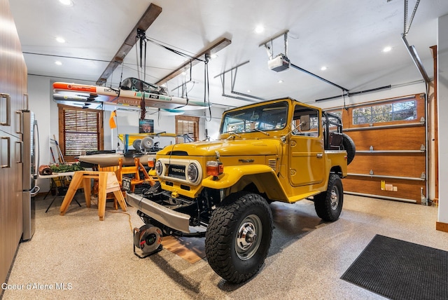 garage with stainless steel refrigerator and a garage door opener