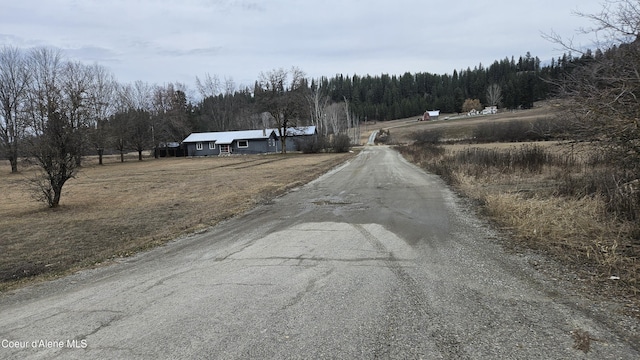 view of street with a rural view and a view of trees