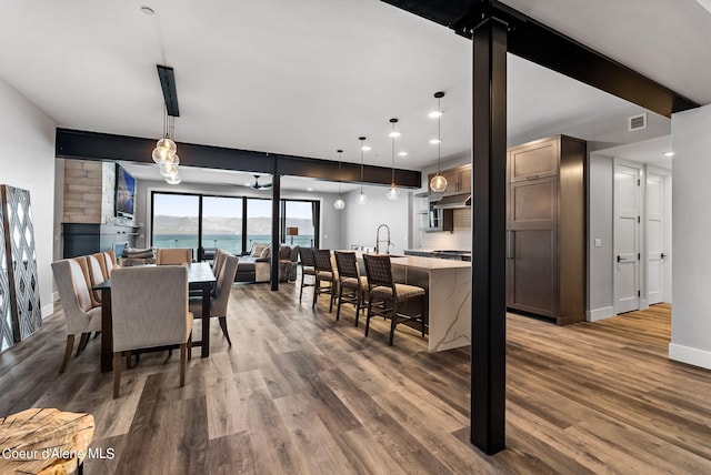 dining area featuring hardwood / wood-style floors, sink, and beamed ceiling