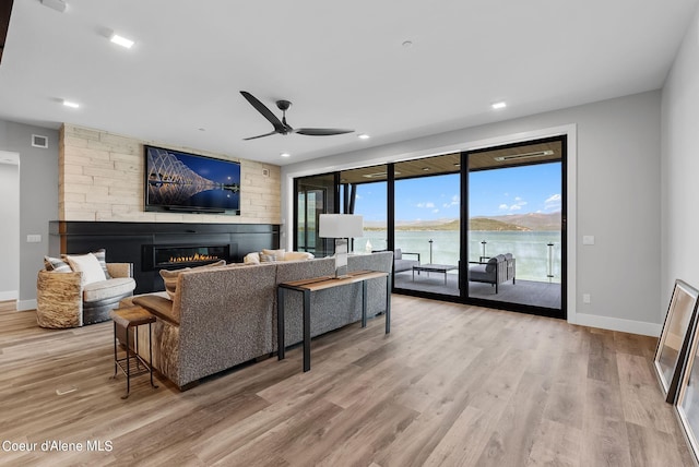 living room with ceiling fan and light wood-type flooring