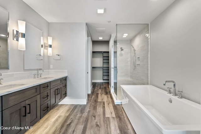 bathroom featuring vanity, wood-type flooring, and shower with separate bathtub