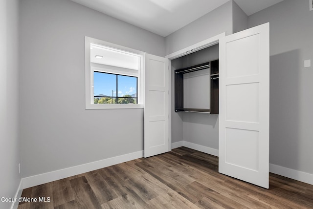 unfurnished bedroom with wood-type flooring and a closet