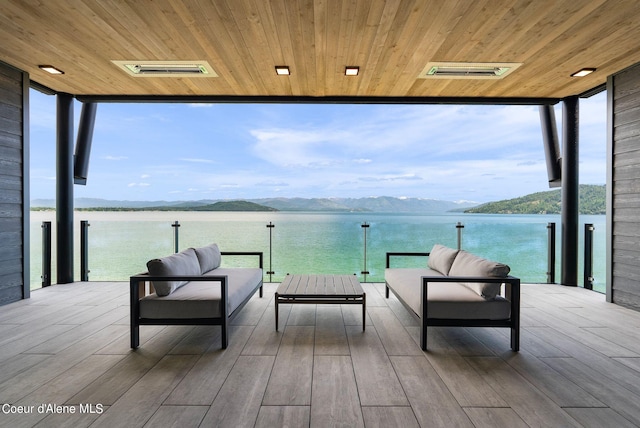 dock area with outdoor lounge area and a water and mountain view