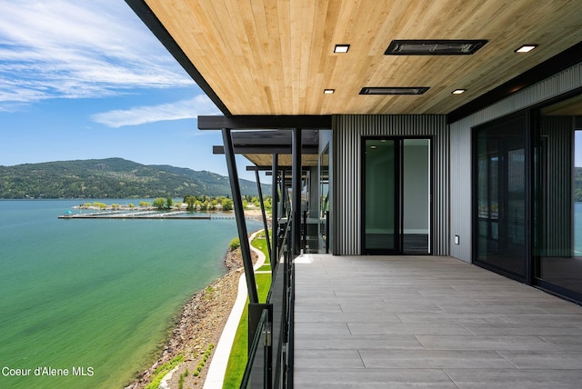 balcony featuring a water and mountain view