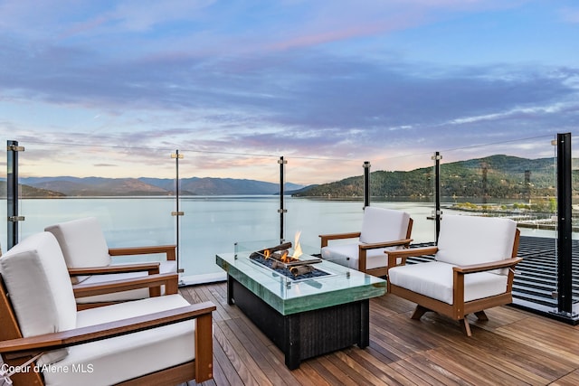 deck at dusk featuring a fire pit and a water and mountain view