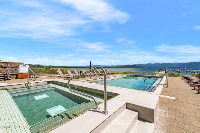 view of swimming pool featuring a water and mountain view