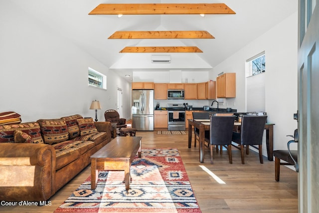 living room with high vaulted ceiling, light wood-type flooring, and beam ceiling