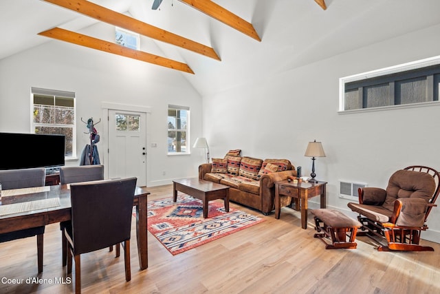 living room with light hardwood / wood-style flooring, high vaulted ceiling, and beamed ceiling