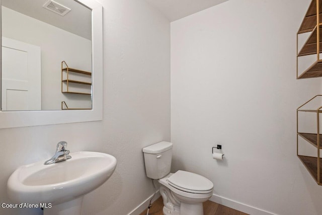 bathroom featuring sink, wood-type flooring, and toilet