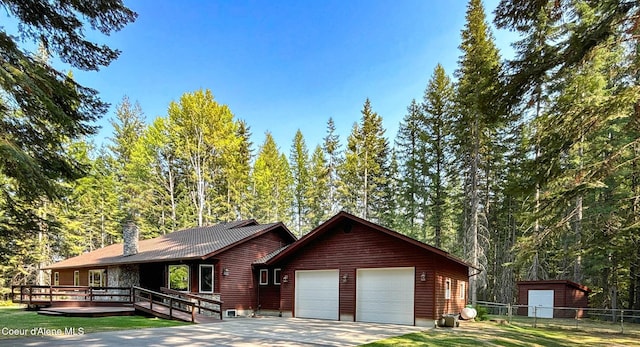 view of front of property featuring a garage, a front yard, and a deck