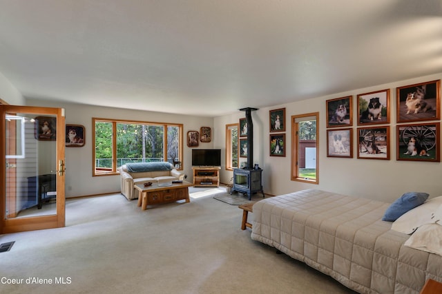 carpeted bedroom with a wood stove