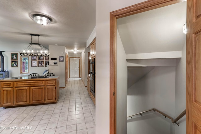 kitchen featuring an inviting chandelier, light tile patterned floors, a textured ceiling, and decorative light fixtures