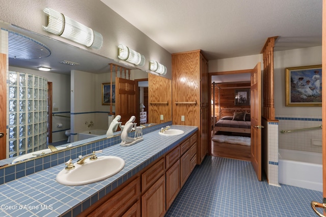 bathroom featuring vanity, tile patterned flooring, and a textured ceiling