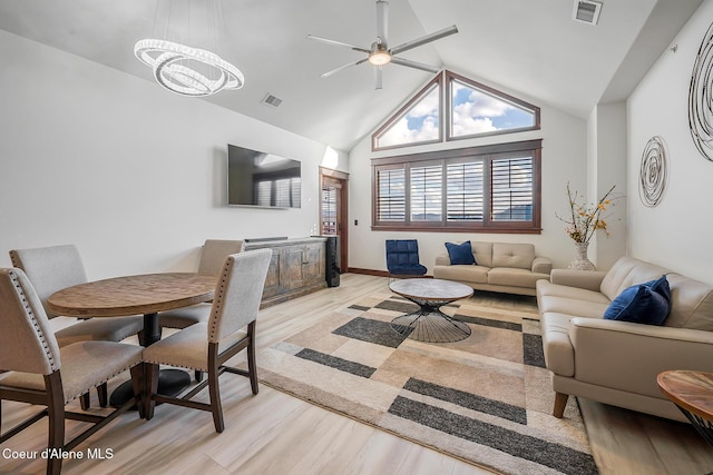 living room with ceiling fan, vaulted ceiling with beams, and light wood-type flooring