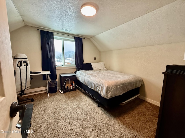 carpeted bedroom with vaulted ceiling and a textured ceiling