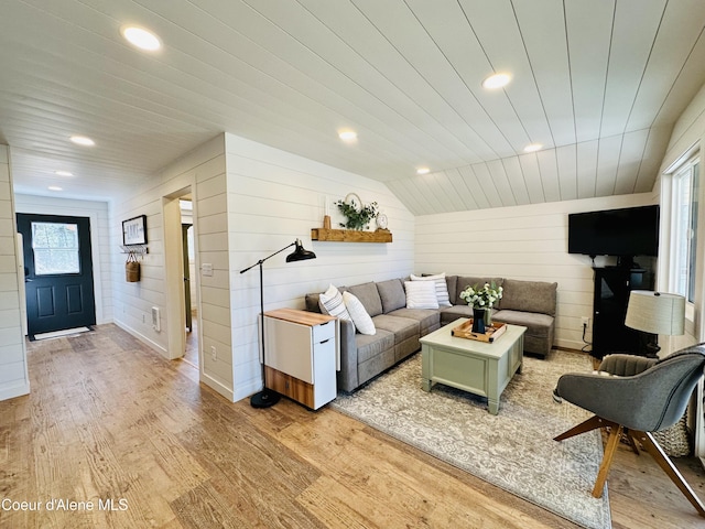 living room featuring vaulted ceiling, light hardwood / wood-style flooring, and wooden ceiling