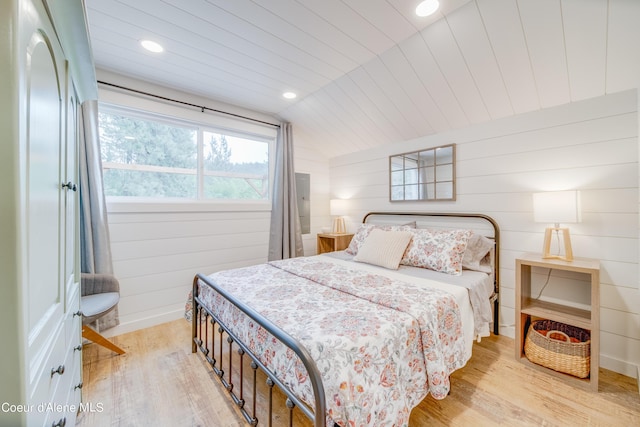 bedroom with lofted ceiling, light hardwood / wood-style flooring, wooden ceiling, and wooden walls