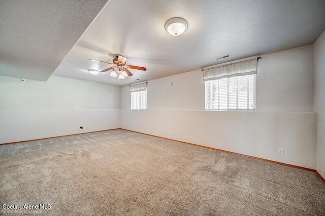 unfurnished room with ceiling fan, carpet floors, and a textured ceiling