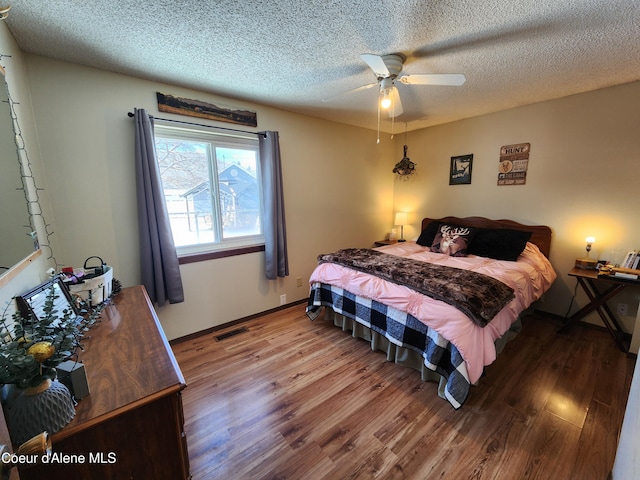 bedroom featuring wood-type flooring, ceiling fan, and a textured ceiling