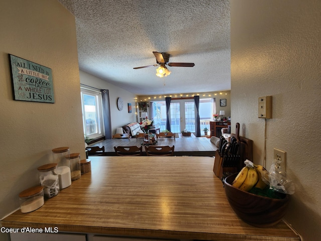 dining space featuring french doors, ceiling fan, and a textured ceiling