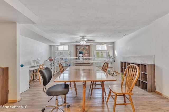 dining room featuring ceiling fan, a textured ceiling, and light wood-type flooring