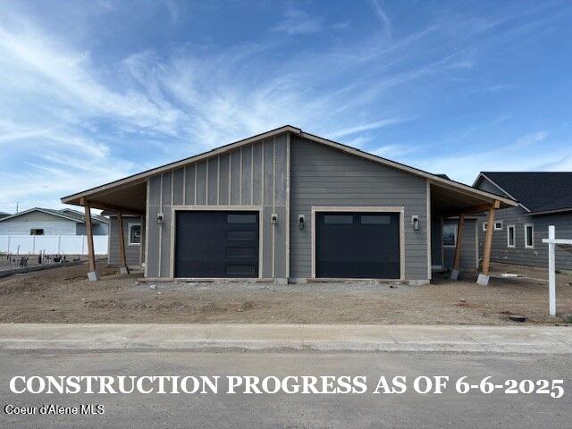 7917 N Mocha Loop, Coeur Dalene, ID 83815 - view of front facade featuring board and batten siding, a garage, and dirt driveway