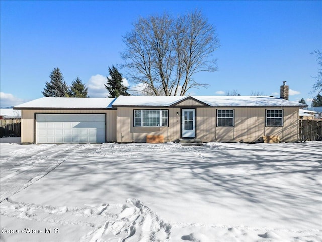 view of front of home with a garage, a chimney, and fence