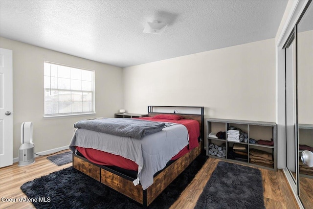 bedroom featuring a textured ceiling, a closet, and wood finished floors