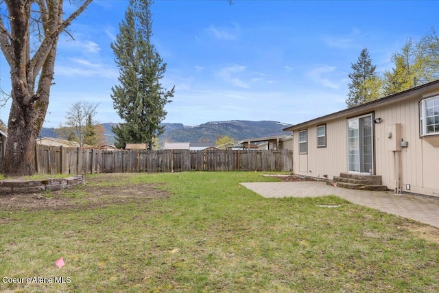 view of yard with a fenced backyard, a patio area, and a mountain view