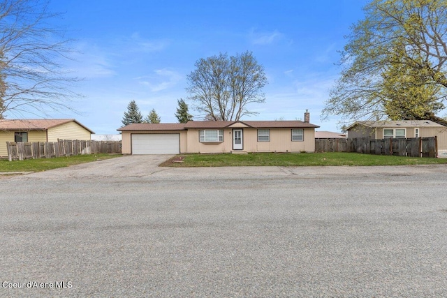 single story home with driveway, a chimney, a front yard, a garage, and fence