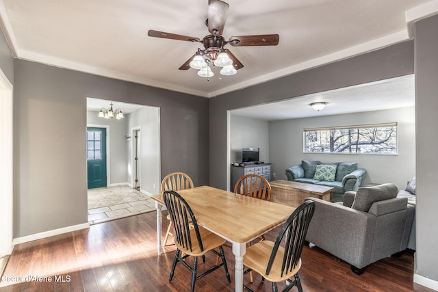 dining room featuring crown molding, dark hardwood / wood-style floors, and ceiling fan with notable chandelier