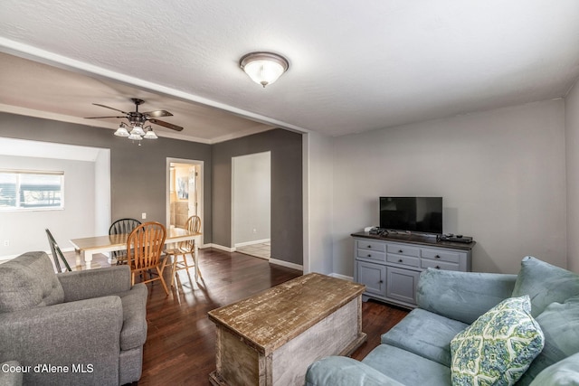 living room with dark hardwood / wood-style flooring and ceiling fan