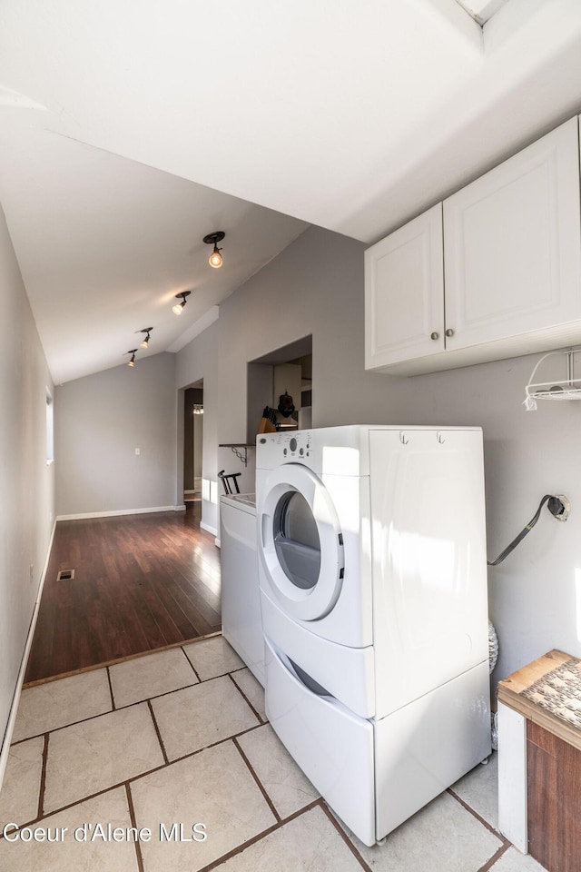 clothes washing area with light tile patterned flooring and separate washer and dryer