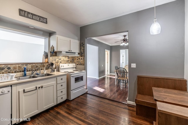 kitchen featuring white cabinetry, sink, decorative backsplash, hanging light fixtures, and white appliances