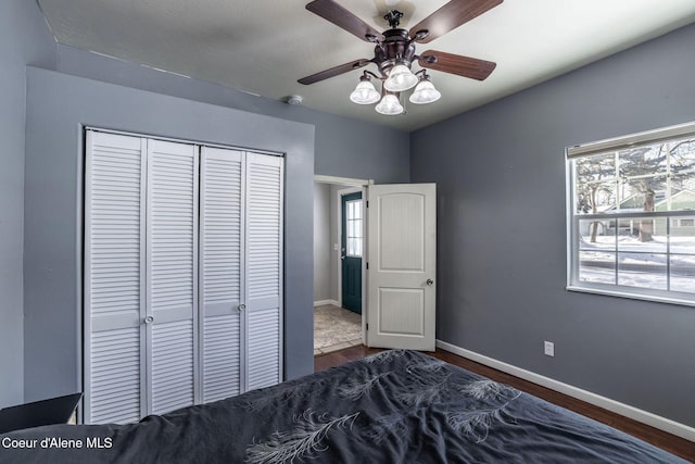 unfurnished bedroom with dark wood-type flooring, ceiling fan, and a closet