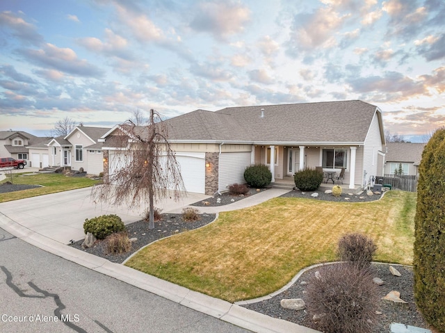 single story home with a garage, covered porch, and a lawn