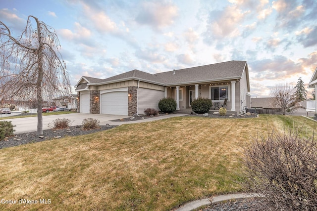 view of front of home with a garage, a porch, and a front lawn