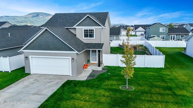 view of front of property with a garage, a mountain view, and a front lawn