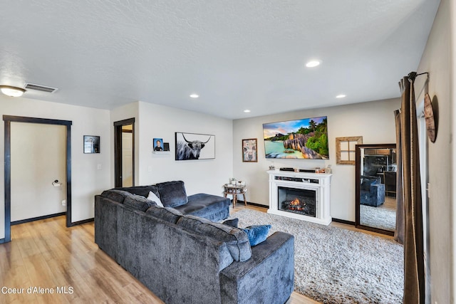 living room featuring a textured ceiling and light wood-type flooring