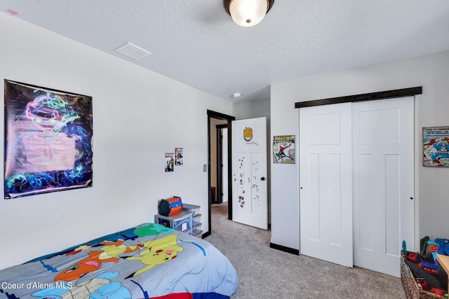 bedroom with a closet, light carpet, and a textured ceiling